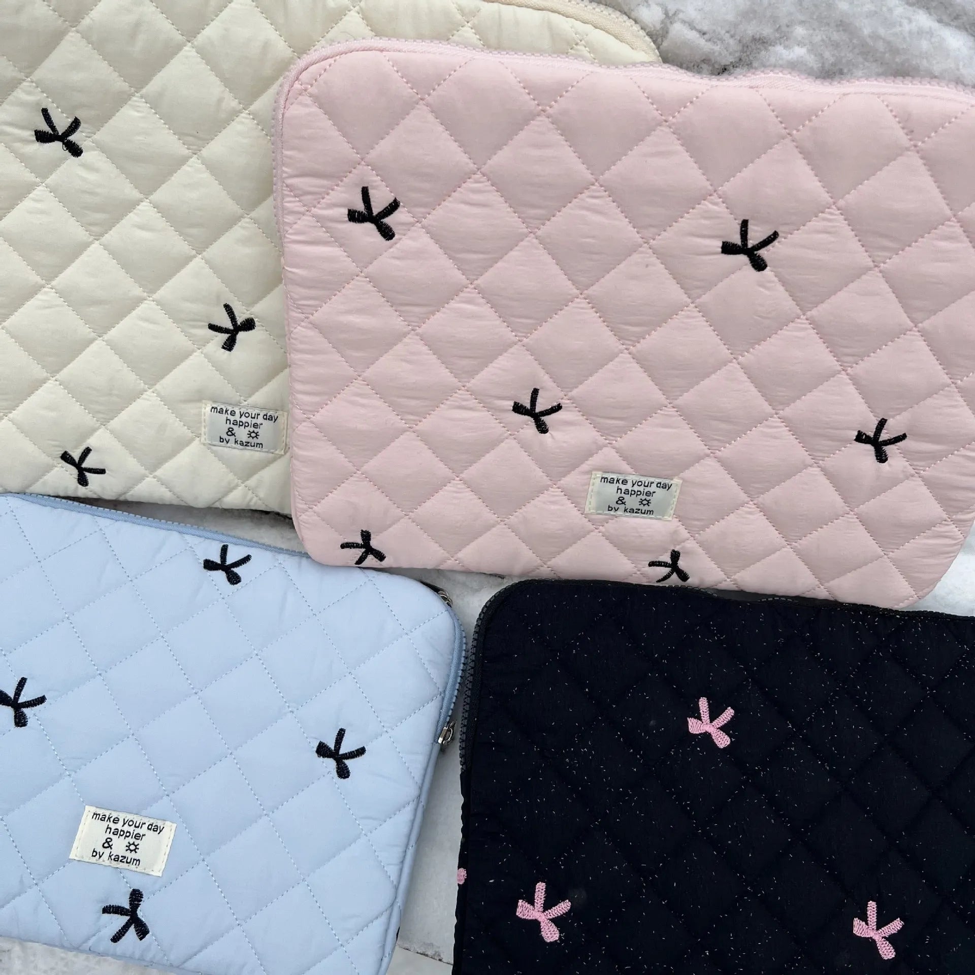 Nylon laptop storage bag with a rhombus-shaped embroidered bow on the front.
