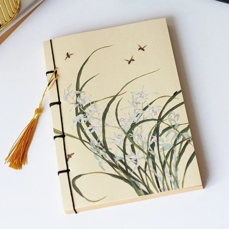 A5 antique wire-bound notebook with glossy embossed cover featuring a retro painting design, shown open.