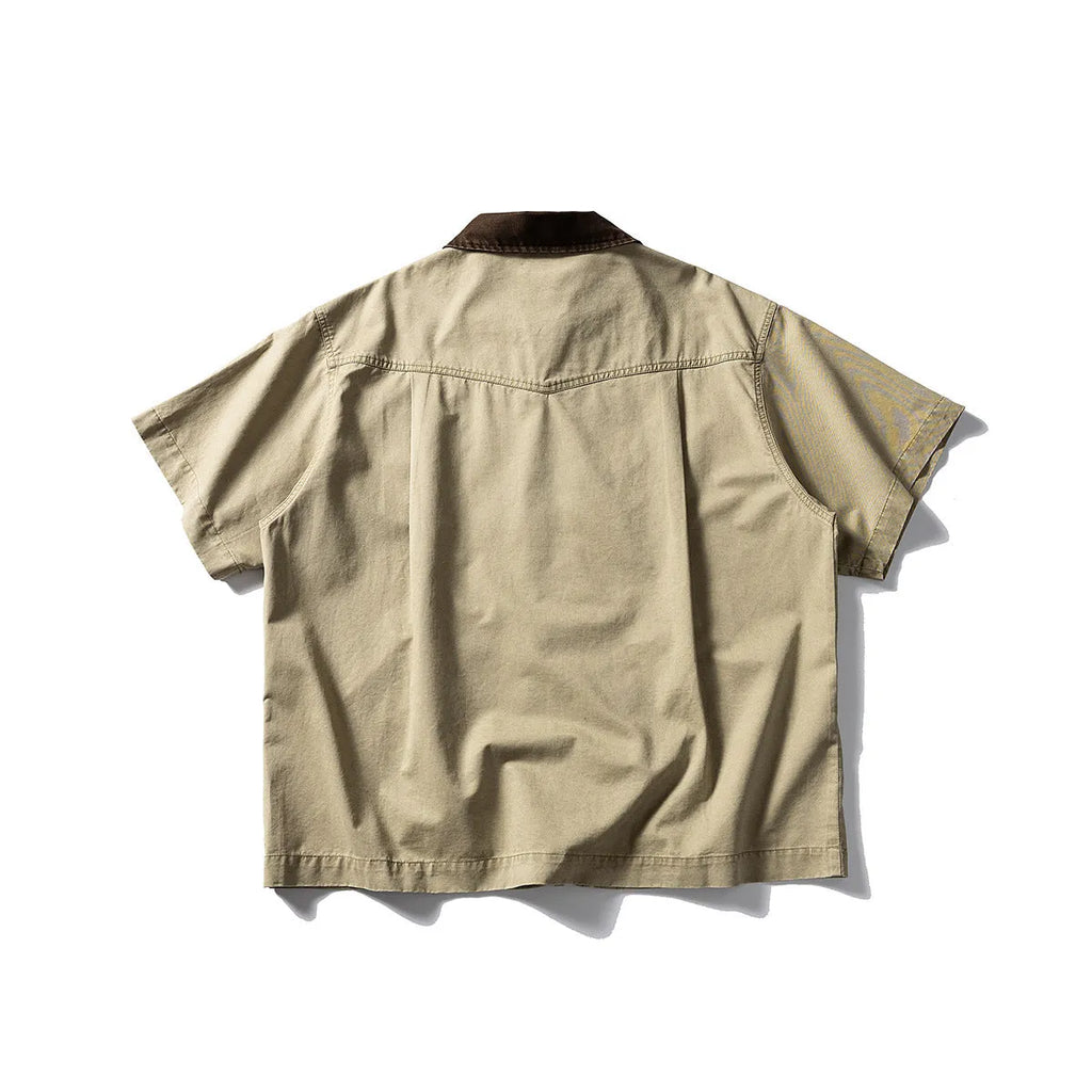 Man wearing a khaki short sleeve overall shirt in a loose cardigan style.