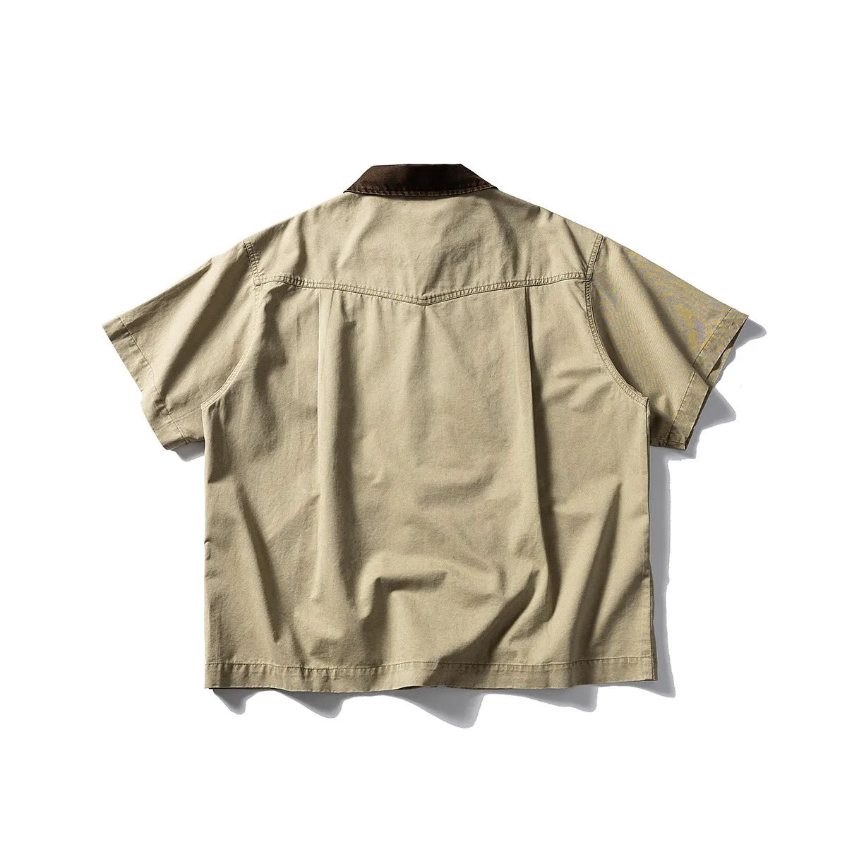 Man wearing a khaki short sleeve overall shirt in a loose cardigan style.