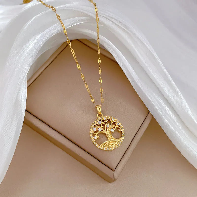 Gold plated stainless steel necklace with mother of pearl lucky tree pendant and cross elements on a lip chain