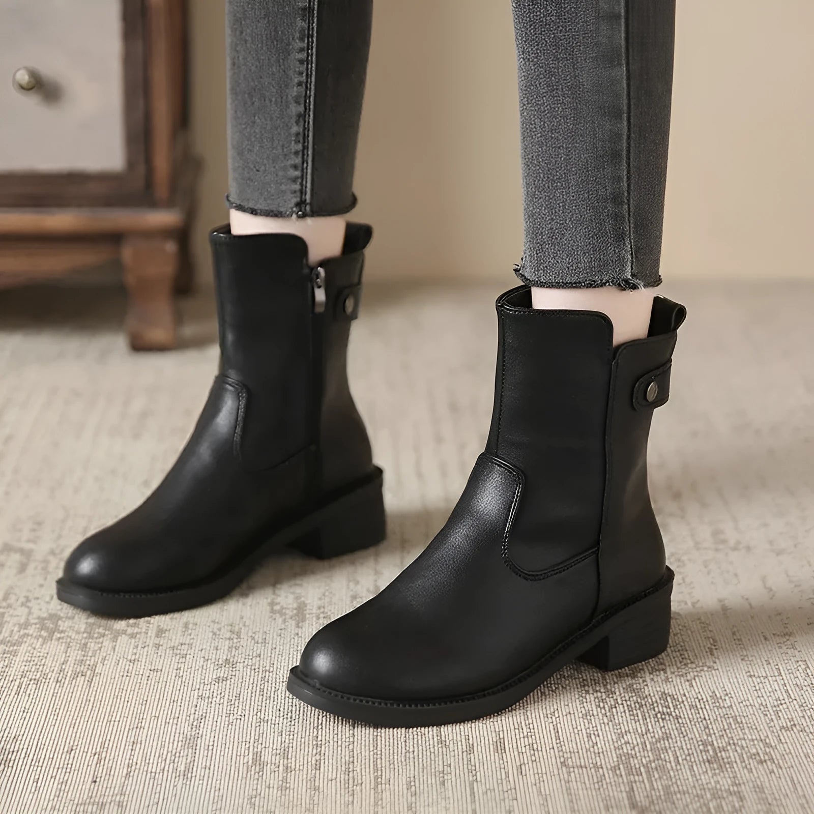 Black women's ankle boots with a side zip and round toe on a low heel.