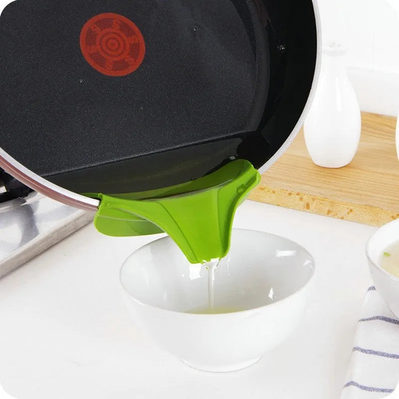 Green silicone soup funnel, 12 x 3 x 4.5 cm, clipped to edge of round pot for pouring