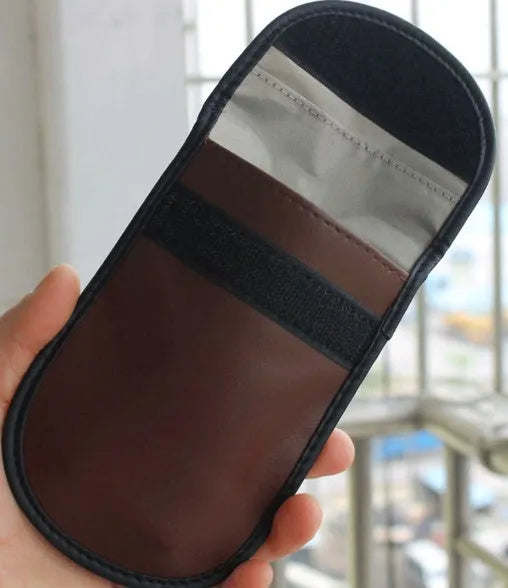 Black microfiber Faraday pouch for blocking mobile phone signals and shielding RFID cards.