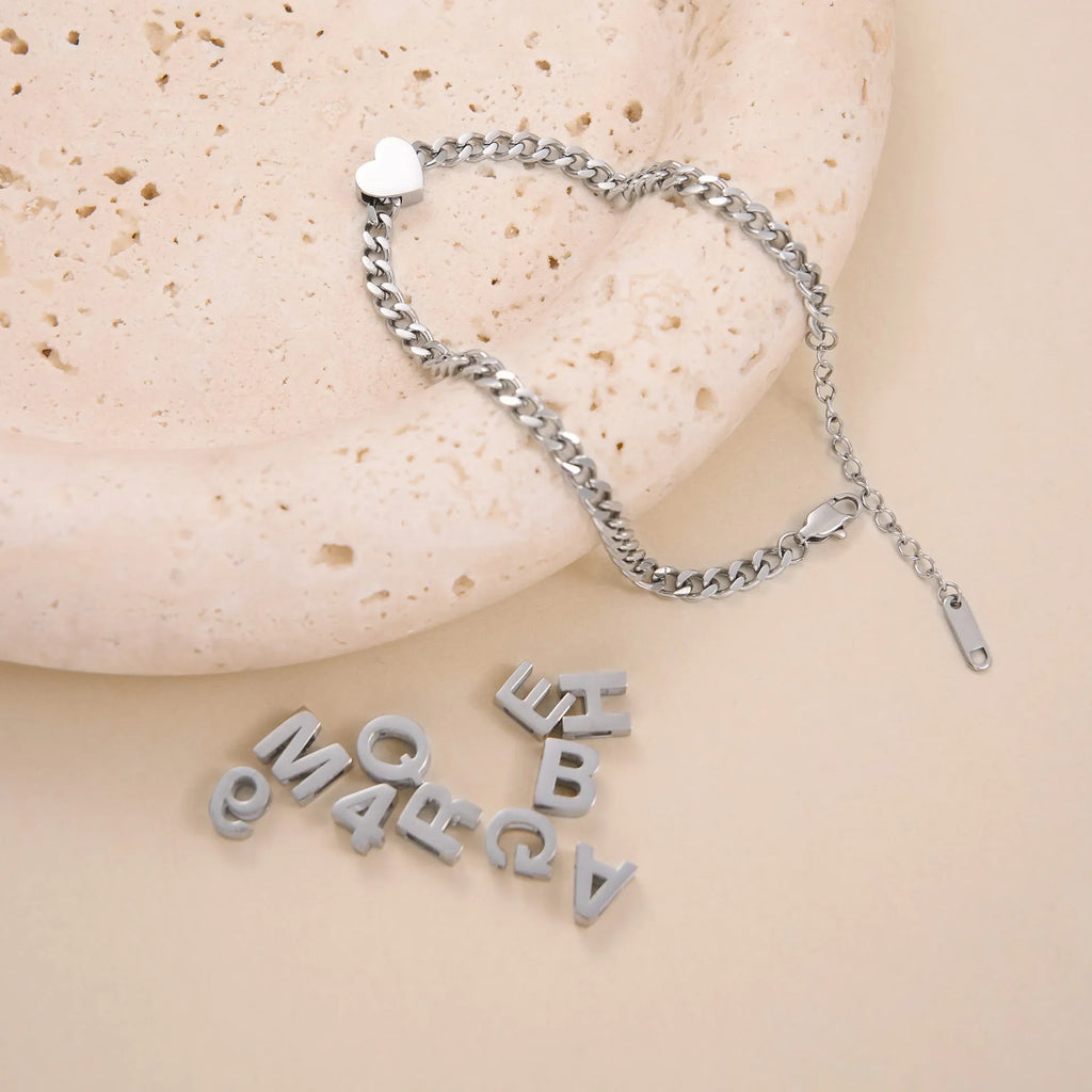 Gold electroplated titanium steel necklace with a letter A charm on a grinding chain.