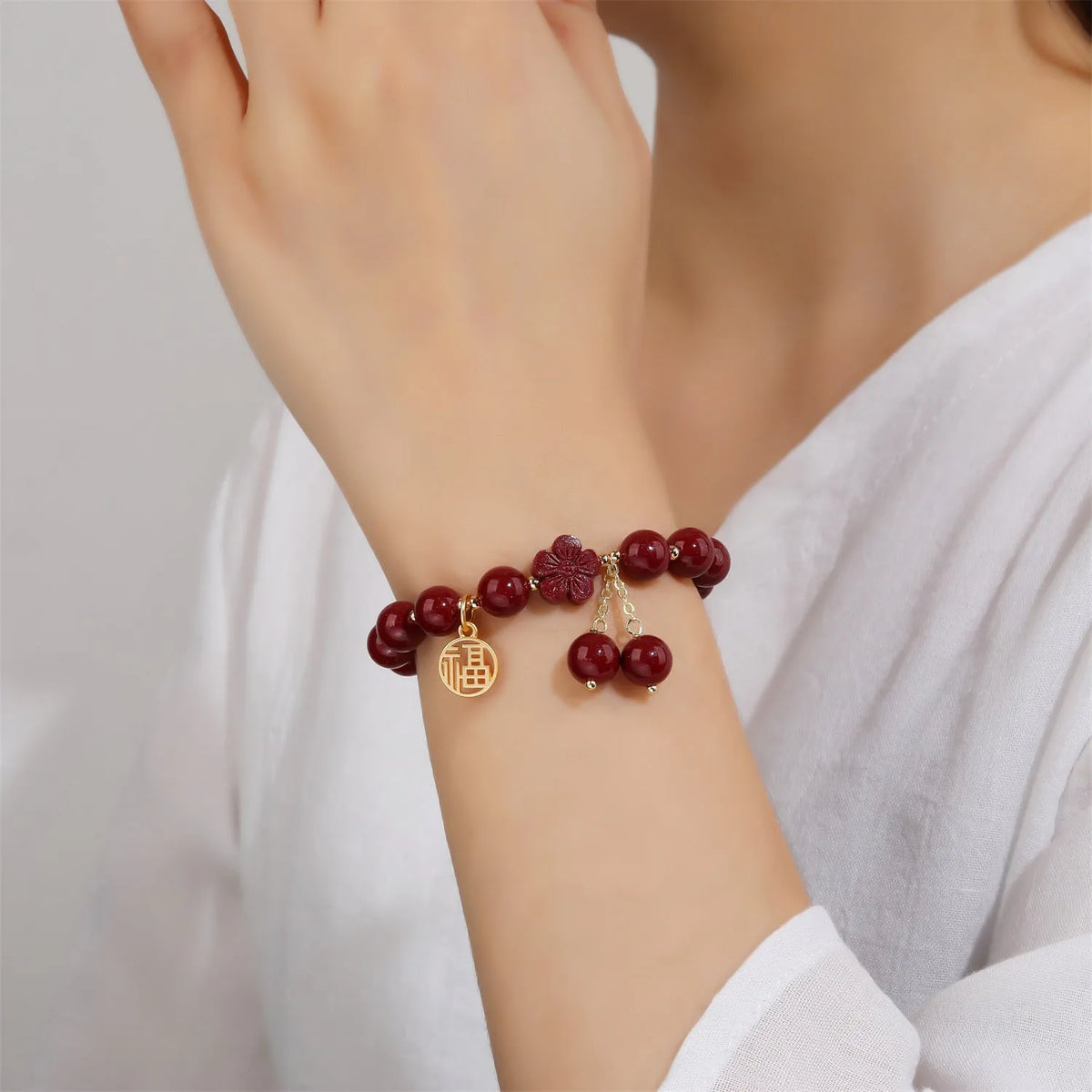Women's cinnabar and purple gold sand bracelet with Fu character peach blossom or Hetian jade flower national style design and tassel detailing