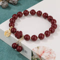 Women's cinnabar and purple gold sand bracelet with Fu character peach blossom or Hetian jade flower national style design and tassel detailing