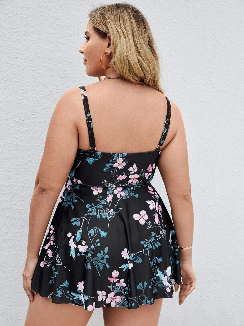 Women's floral print one-piece swimsuit with split colour design on a mannequin.
