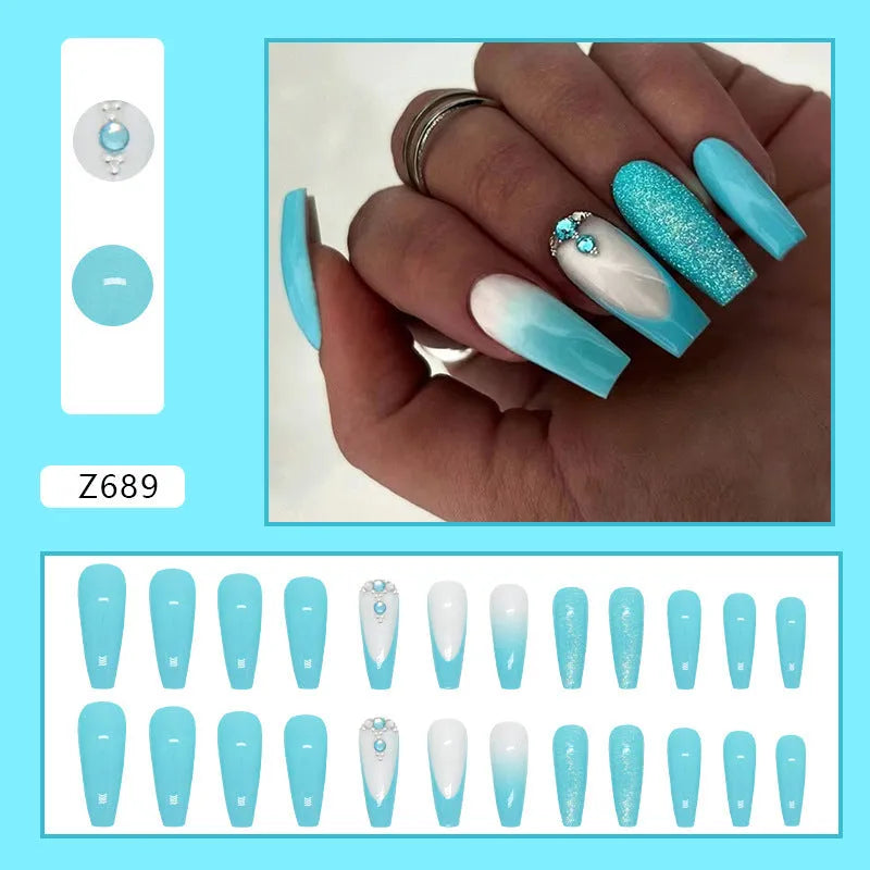 Solid blue long ballet shaped false nail art patches with a bottle of adhesive glue on a white background.