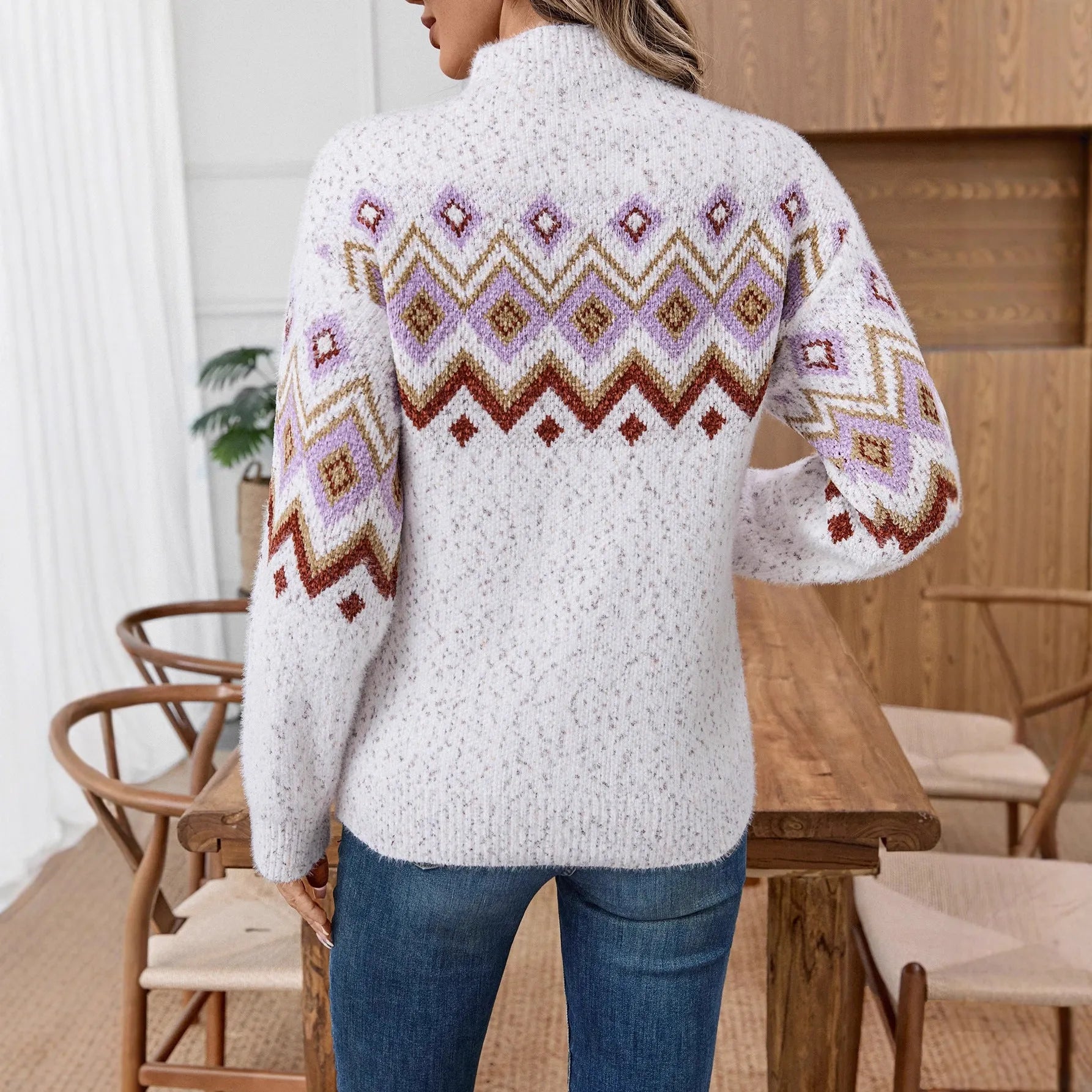 White women's loose geometric jacquard pullover sweater with long sleeves and a half-turtleneck.