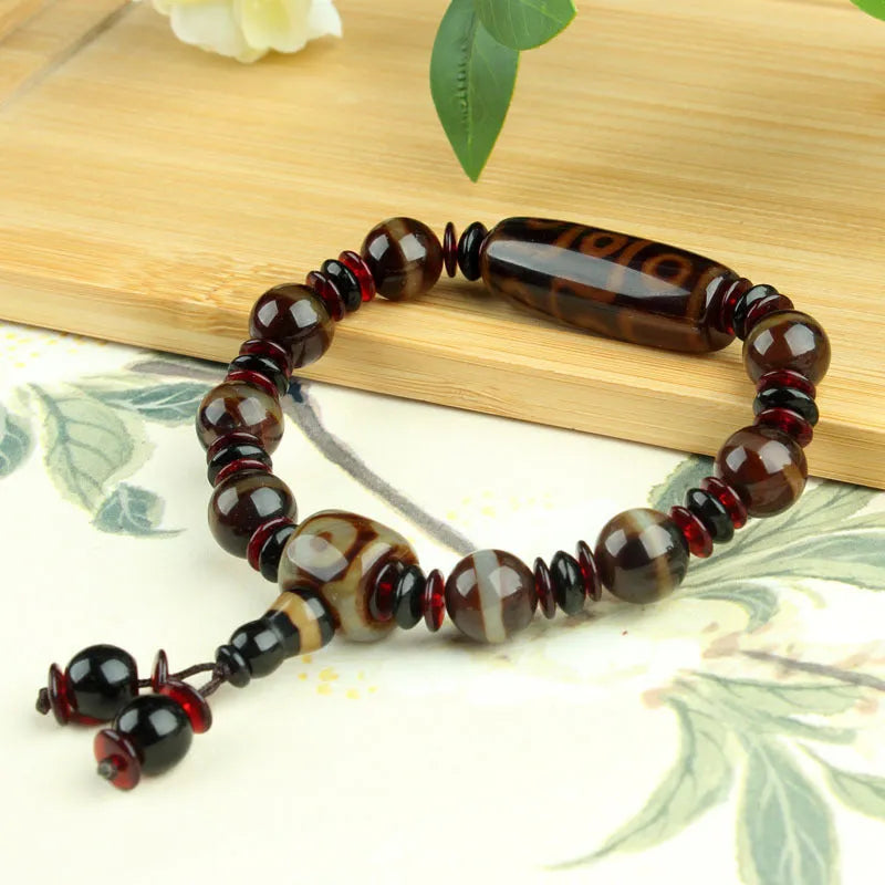 Distressed agate bracelet with traditional Tibetan dzi beads including three-eye and Nine Eyes designs.