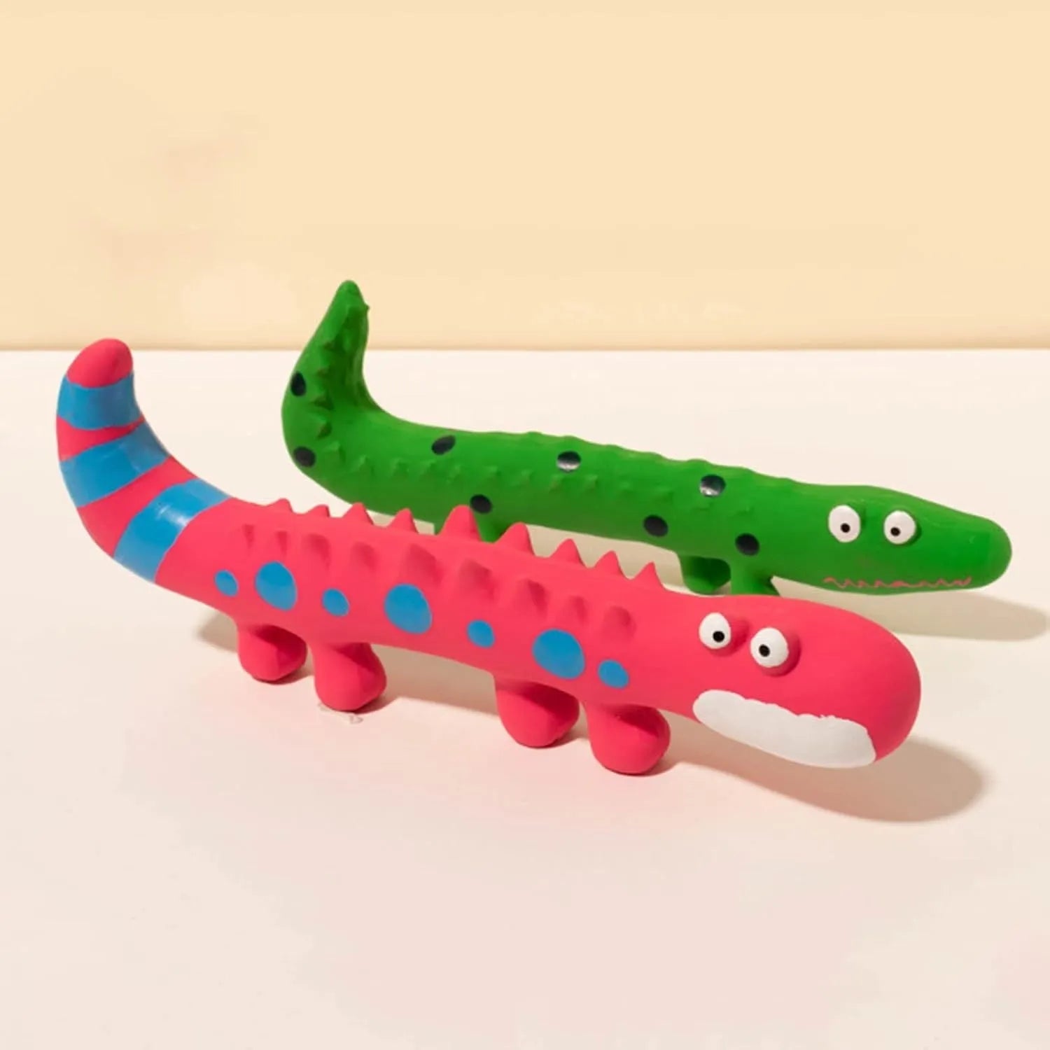 Green cartoon lizard-shaped latex dog chew toy with squeaker on a white background