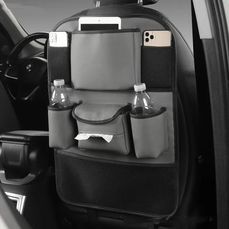 Synthetic leather car seat back storage bag hanging on the back of a grey car seat.