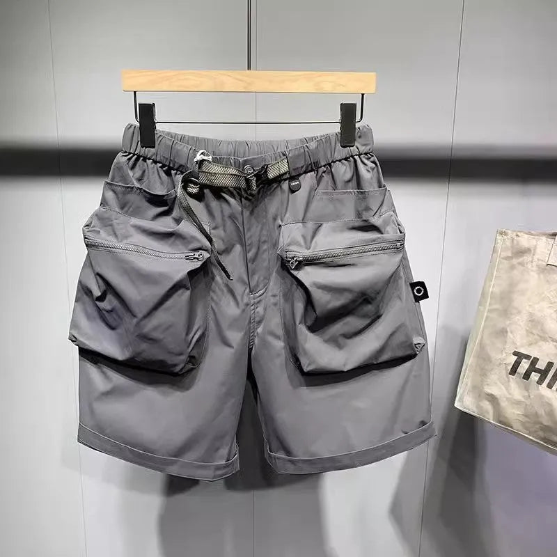Men's loose fit grey workwear shorts with pockets, shown above the knee.