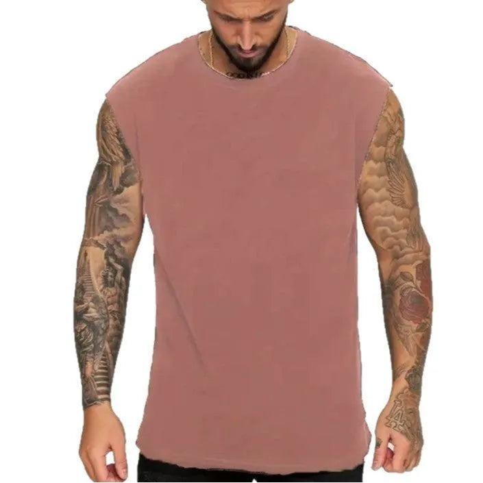 Man wearing a loose apricot-coloured cotton tank top, showing the sleeveless design and straight hem.