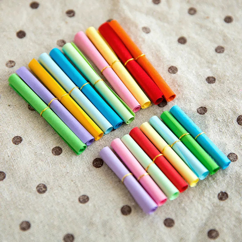 Colourful drift bottle message paper scrolls in various sizes with metal eyelets for hanging.