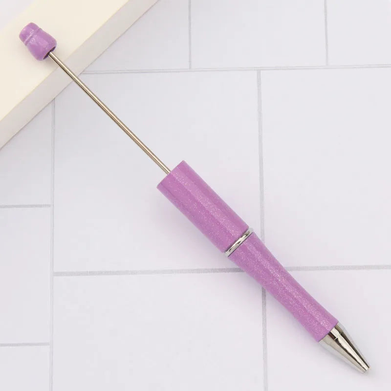 Ballpoint pen with colourful spinning plastic beads on barrel, shown in a gradient purple finish.