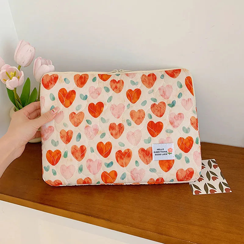 Printed cloth laptop bag for women shown in floral and heart patterns, available in small, medium, and large sizes.