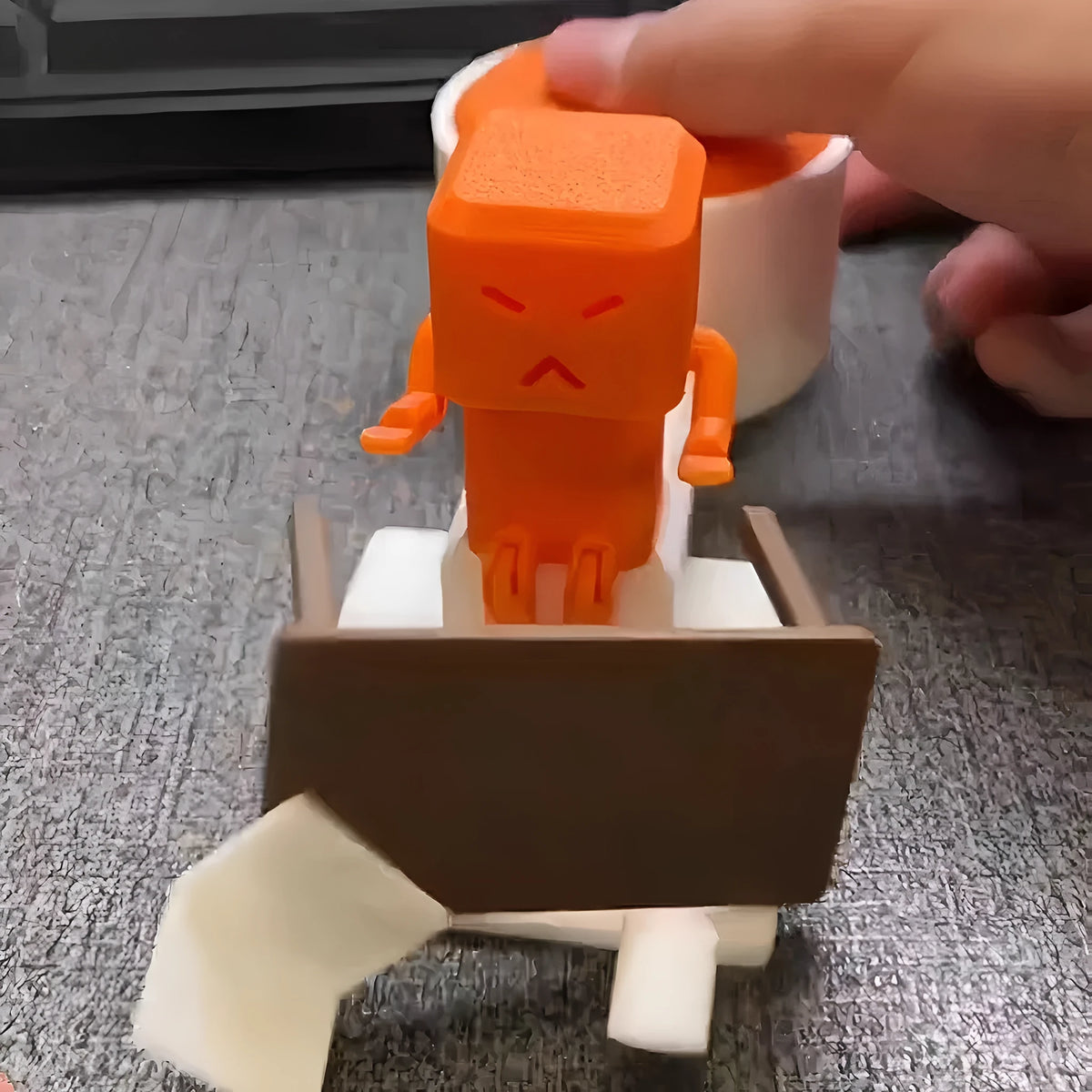 Orange plastic vent decompression toy with push buttons on a desk