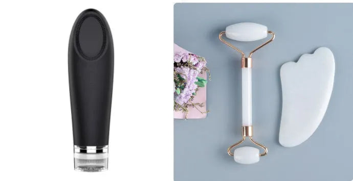 White jade facial roller and gua sha scraper board set on a plain surface.