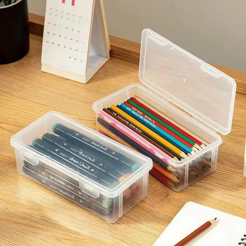 Transparent plastic stationery storage box containing pencils, colour leads, and art supplies