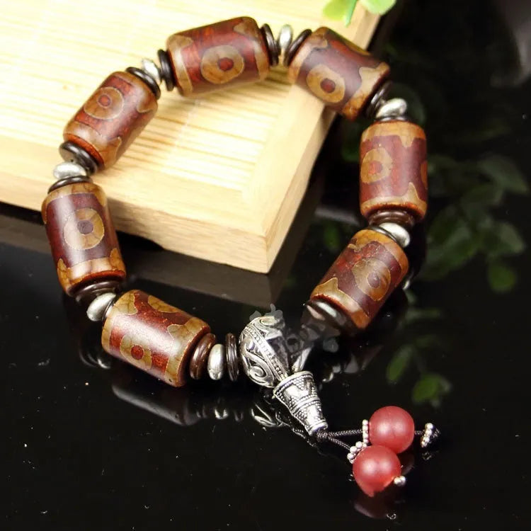 Distressed agate bracelet with traditional Tibetan dzi beads including three-eye and Nine Eyes designs.