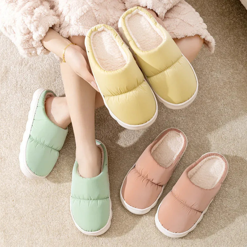 Blue down cotton slippers with artificial leather upper, thick rubber sole, and plush lining shown on a wooden floor.