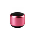 Compact portable Bluetooth wireless speaker shown in one of four colour options: black, blue, gold, or pink.