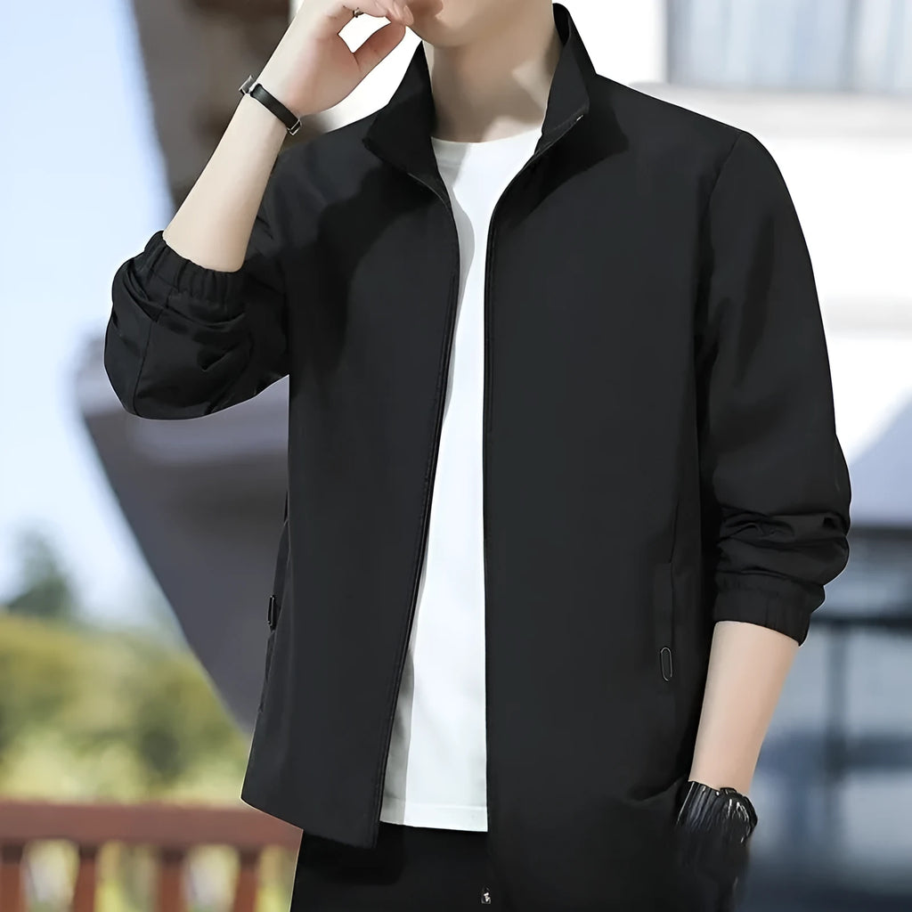 Man wearing a loose fit black Korean style casual jacket with zip pockets.