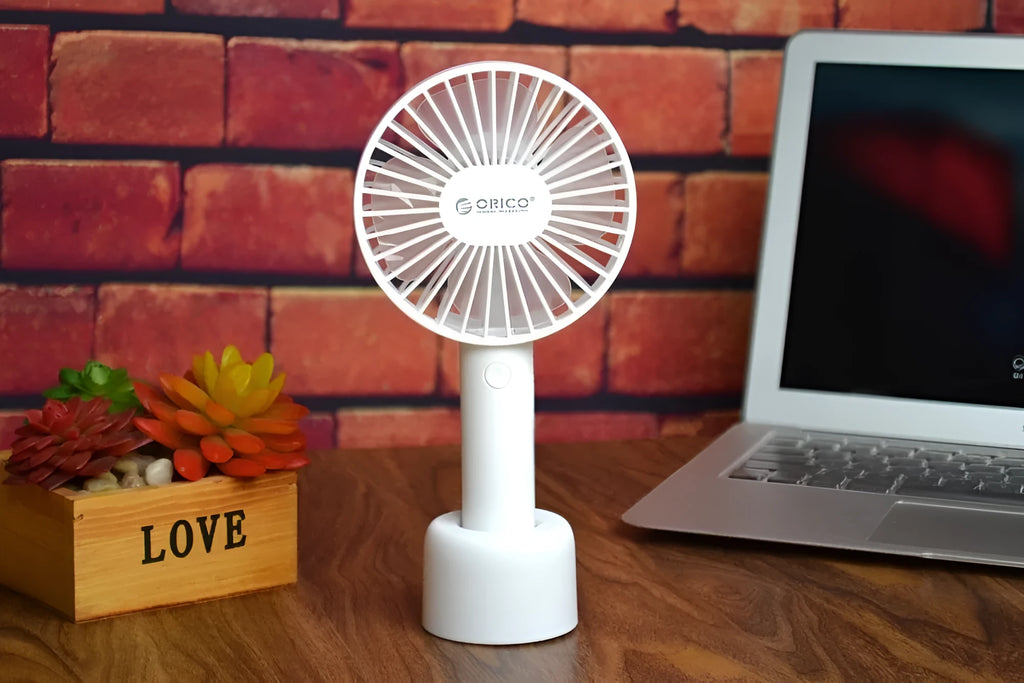 White ORICO FH1 portable USB desk fan with fine-line texture, shown as a handheld and desktop unit.