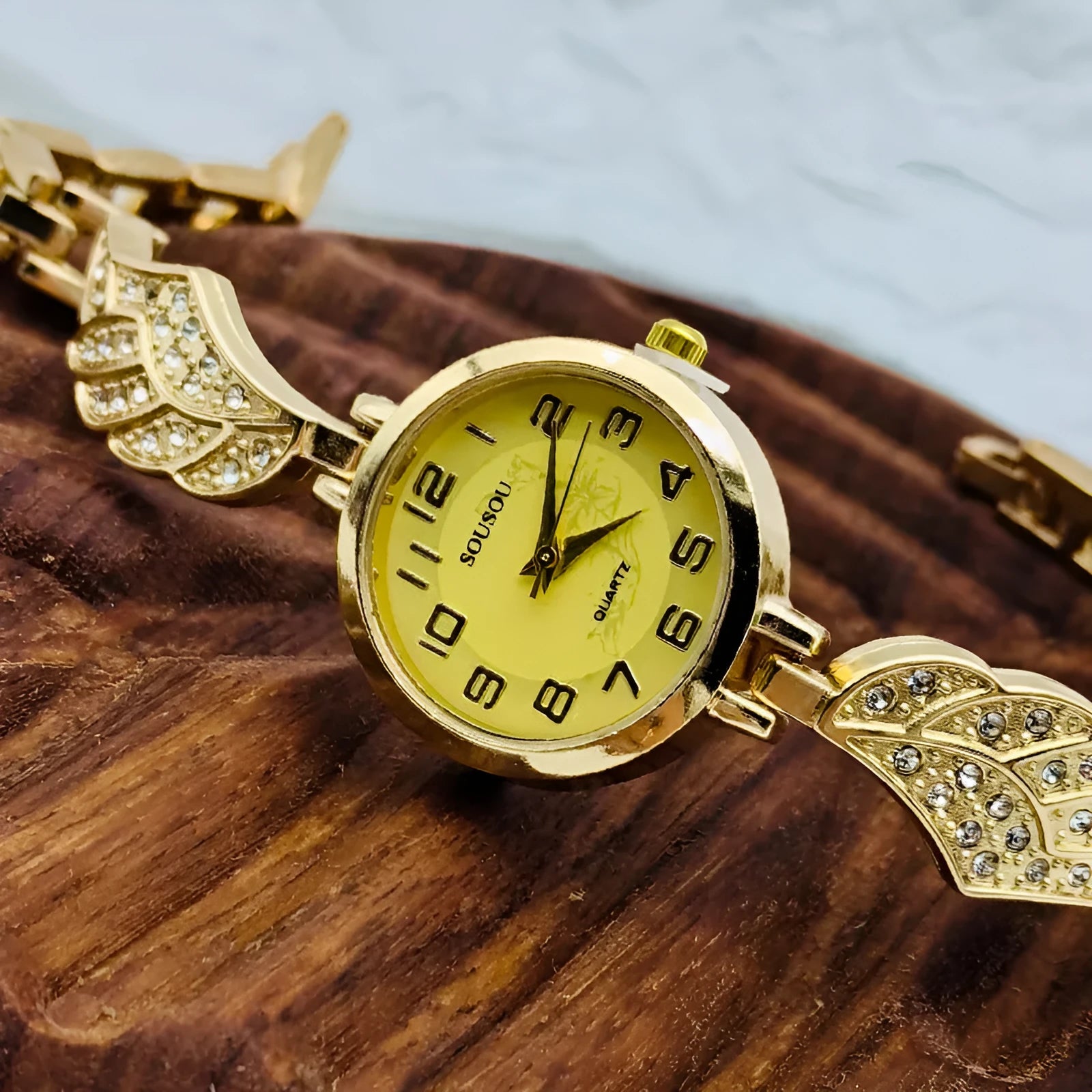 Stainless steel women's watch with round dial and Vachette clasp buckle on wrist.