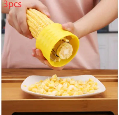 Yellow manual corn grinder thresher tool with corn-shaped design on a kitchen counter.
