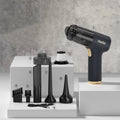 Black wireless car vacuum cleaner with multiple nozzle attachments and a USB charging cable on a car seat.