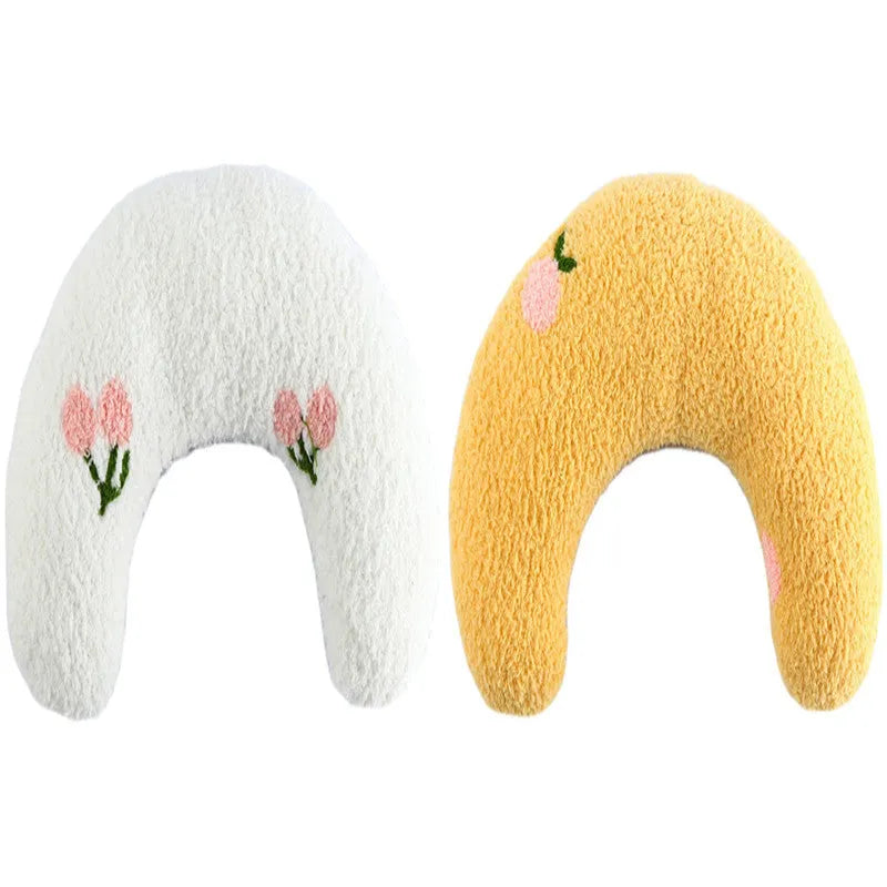 Small blue half-donut shaped pet pillow bed for cats or small dogs on a carpet.