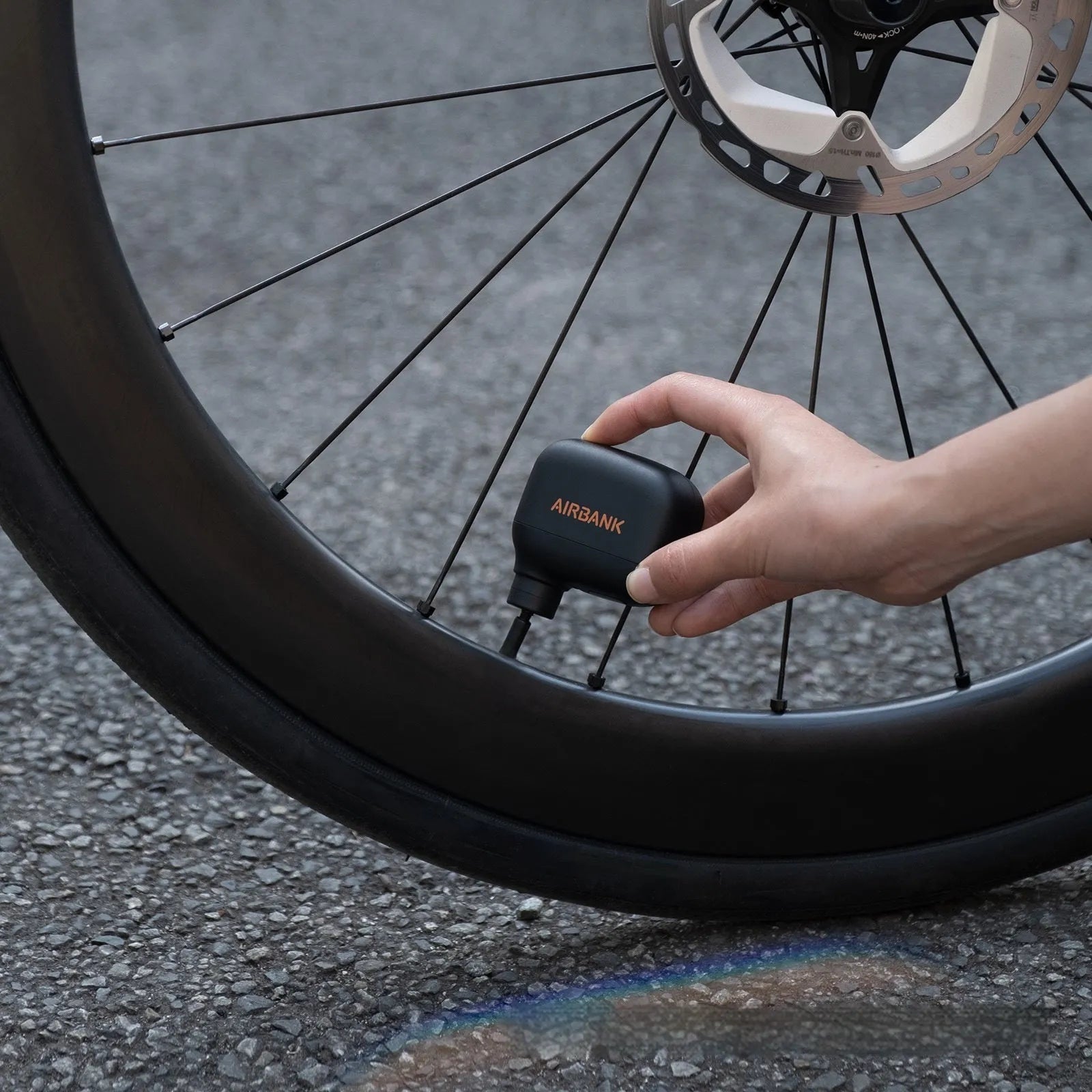 Black AS100 electric bicycle pump with USB charging port showing compact dimensions