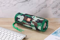 Portable fabric Bluetooth speaker with integrated card holder pocket on side, shown in available colours.