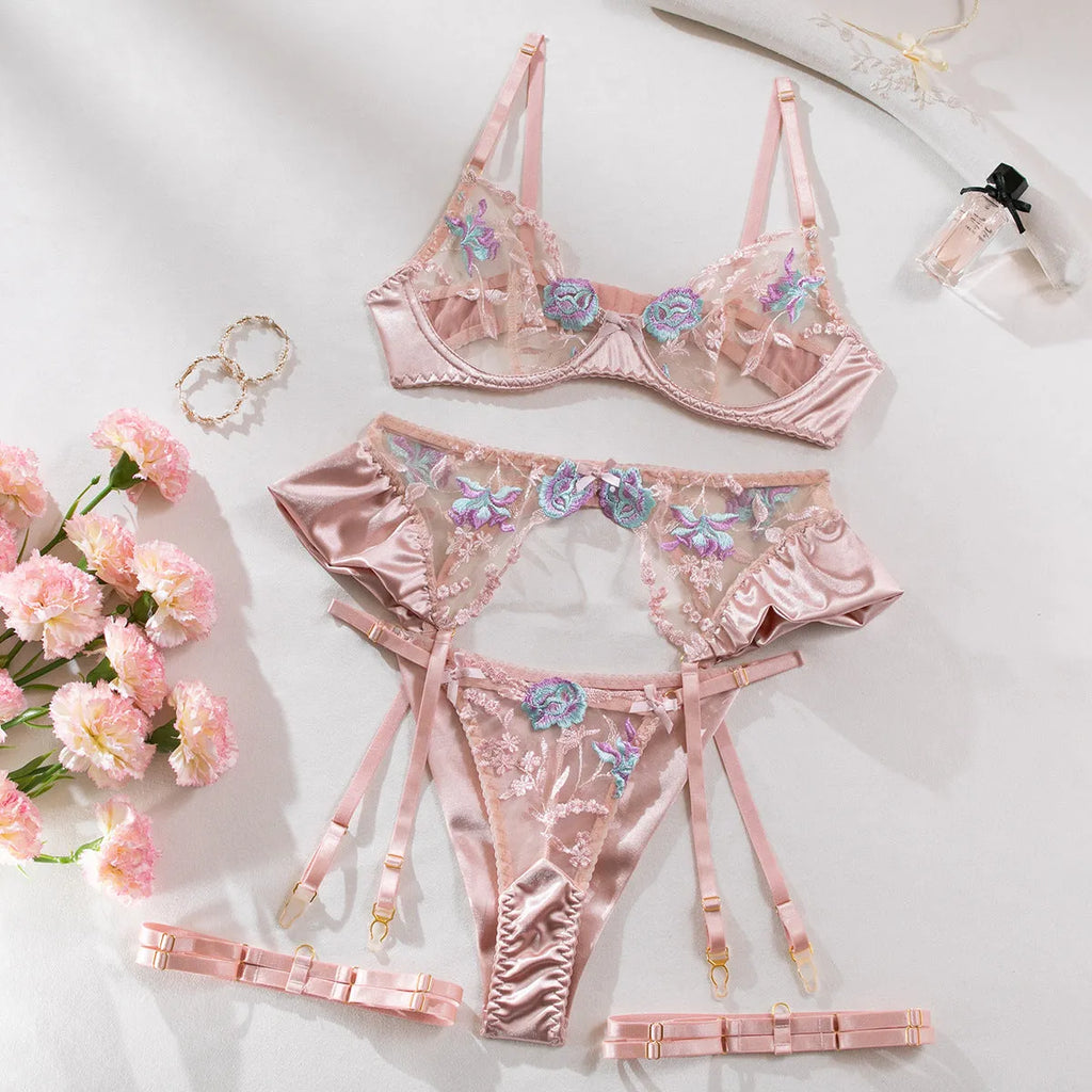 Light purple satin lingerie four-piece set with embroidery detailing on a hanger.