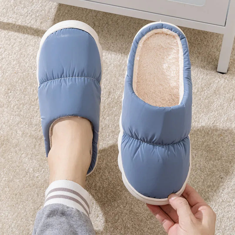 Blue down cotton slippers with artificial leather upper, thick rubber sole, and plush lining shown on a wooden floor.