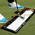 Black rectangular neoprene golf swing stance posture training pad on a green surface.