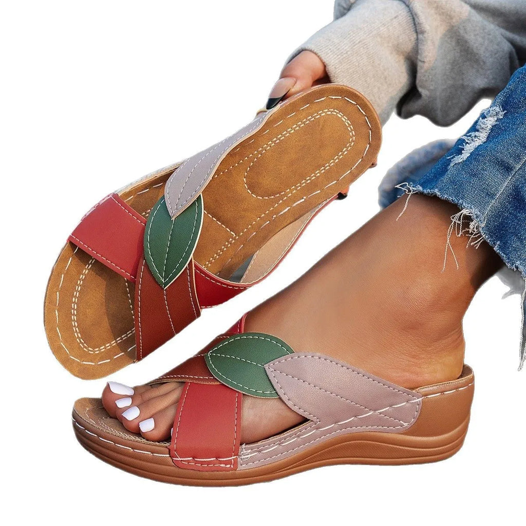 Women's black peep-toe slipper with a cross-strap and thick sole on a white background.