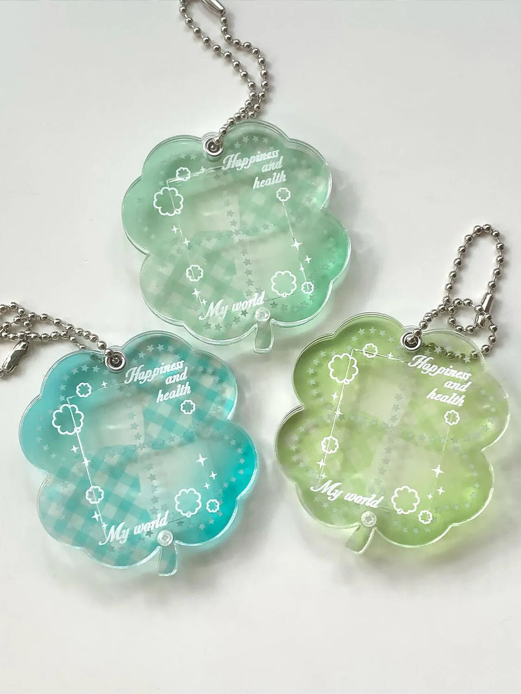 Acrylic four-leaf clover pendant keychain in elegant blue, grass green, and mint green colours.