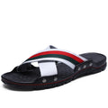 Men's black cowhide leather beach sandals with a non-slip PU sole on a sandy background.