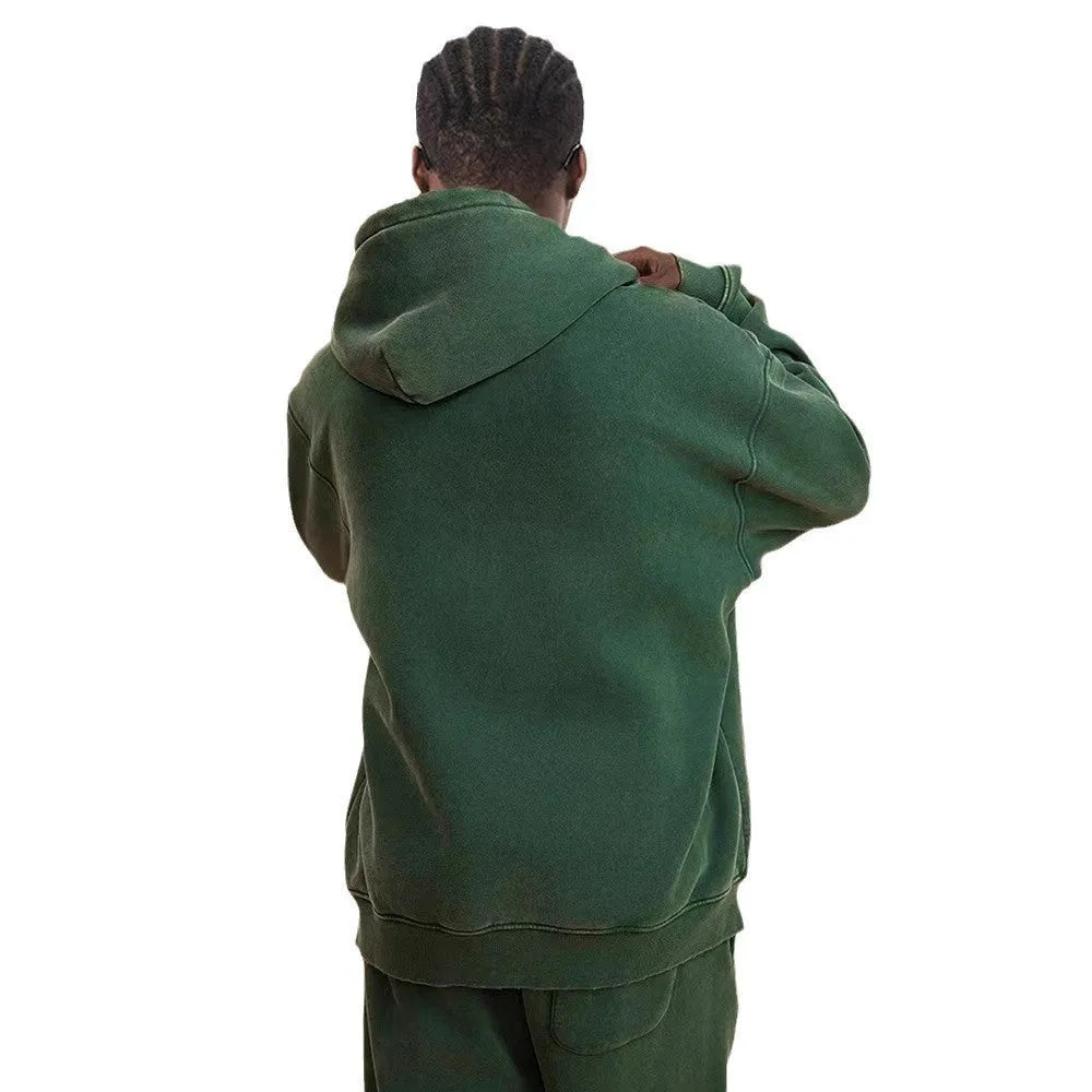 Man wearing a dark green hooded zip-up cardigan with a fleece lining and long sleeves.