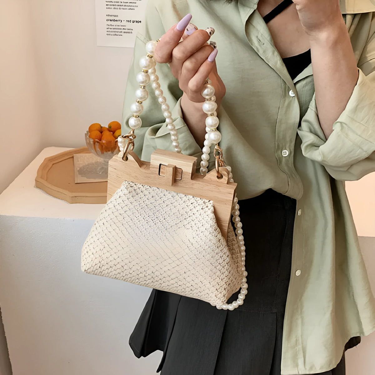 Women's woven straw beach bag with pearl chain shoulder strap in horizontal square shape
