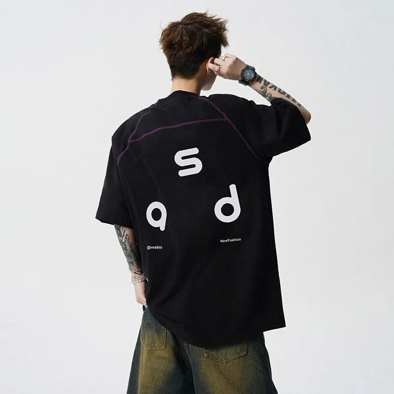 Loose-fitting black cotton T-shirt with a letter print on the chest, showing short sleeves and a round neck.