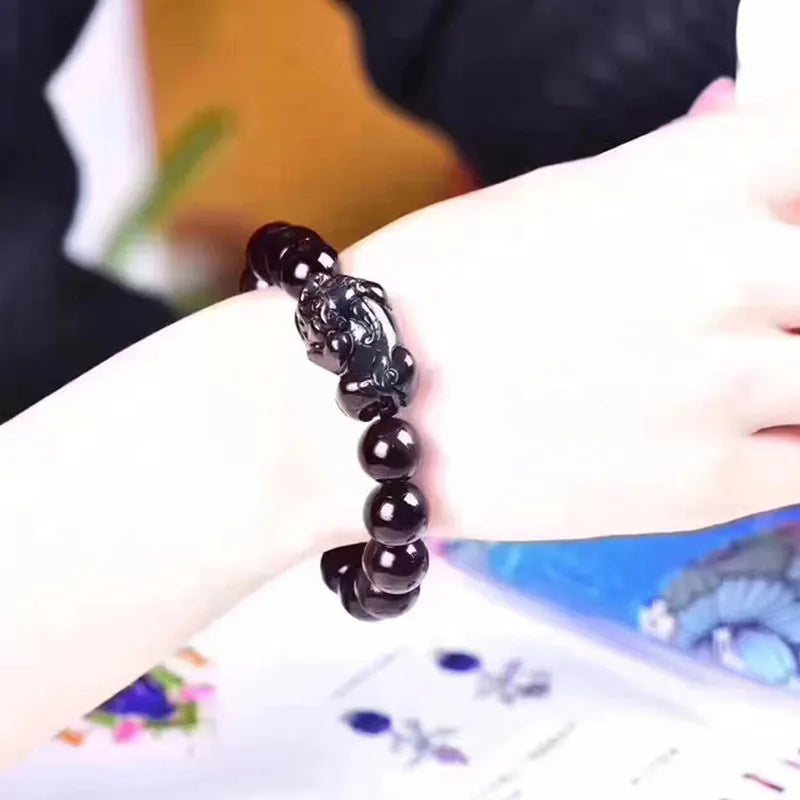 Natural ice colour eye obsidian crystal bracelet on a wrist, showing polished beads.