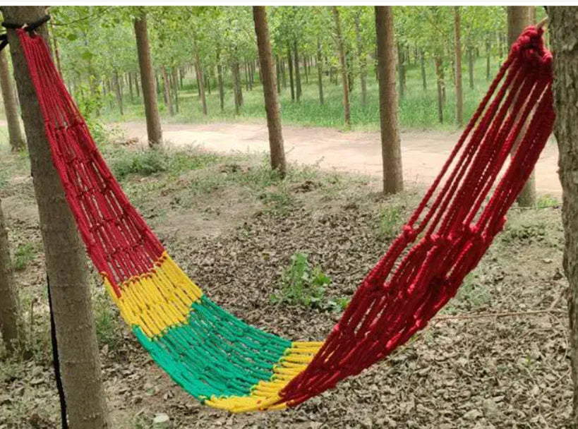 Nylon rope mesh hammock hung outdoors, showing its woven design and included tying ropes.