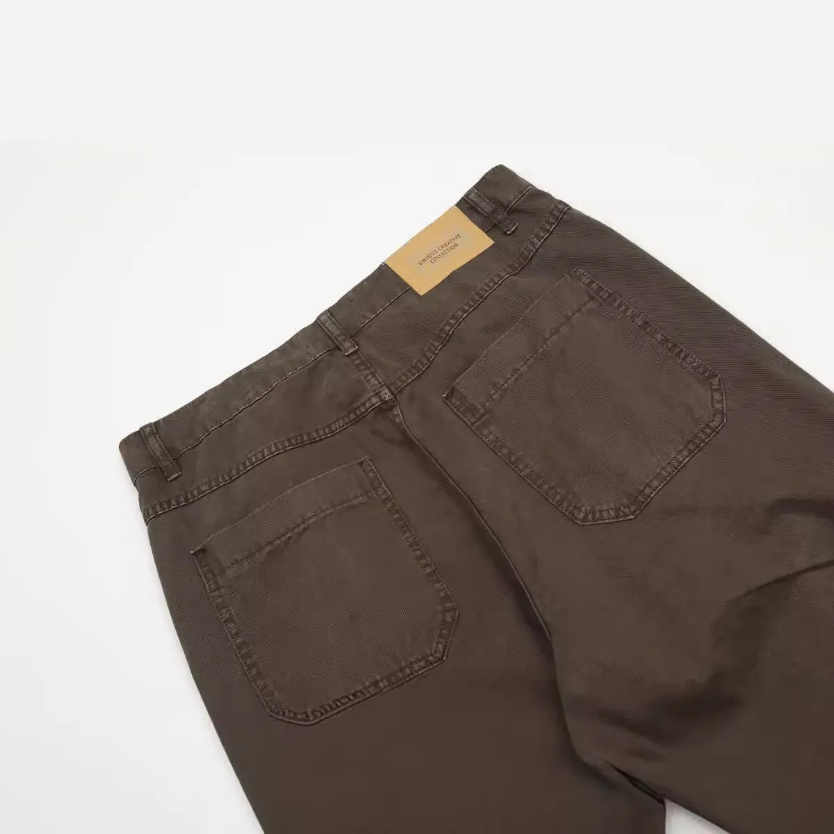 Men's loose straight-leg high-waist jeans in brown cotton fabric laid flat