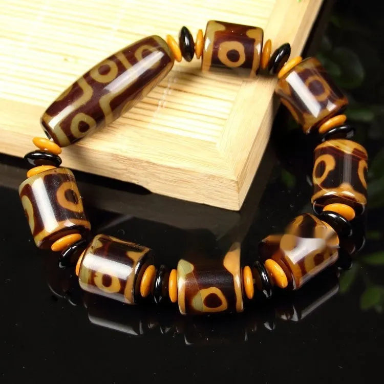 Distressed agate bracelet with traditional Tibetan dzi beads including three-eye and Nine Eyes designs.