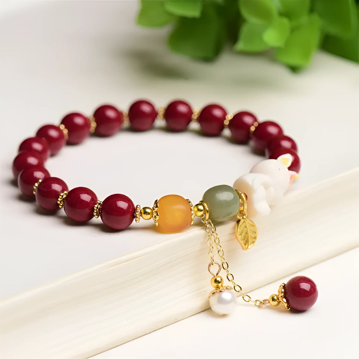 Natural cinnabar bracelet with rabbit charm for women, shown in 8mm and 10mm bead size options.